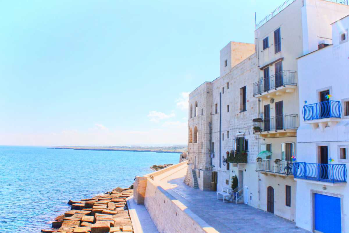 Facciate di palazzo barocco leccese con balconate ornate in pietra gialla, dettagli scolpiti e finestre con cornici elaborate