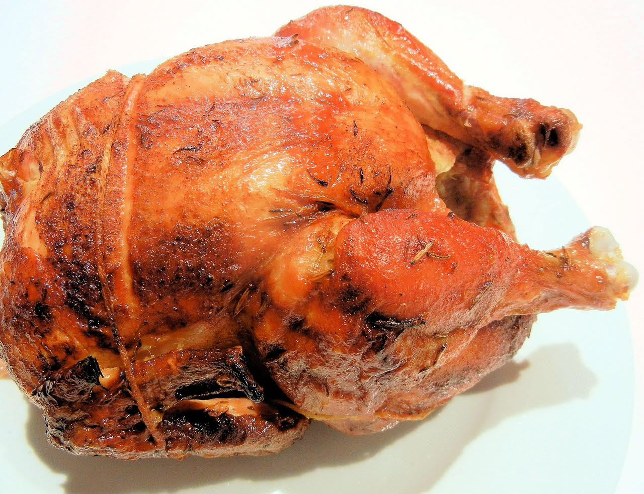 Confezione di pollo fresco in vaschetta di plastica trasparente con etichetta bianca in primo piano su scaffale di supermercato illuminato