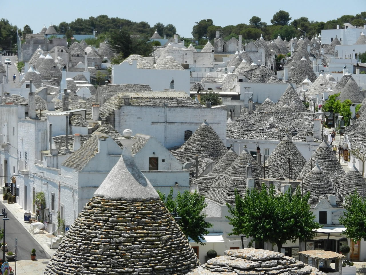 Masseria rurale con tetto a coppi in laterizio rosso, muri in pietra calcarea bianca e piccola pendenza, scena di campagna pugliese al tramonto