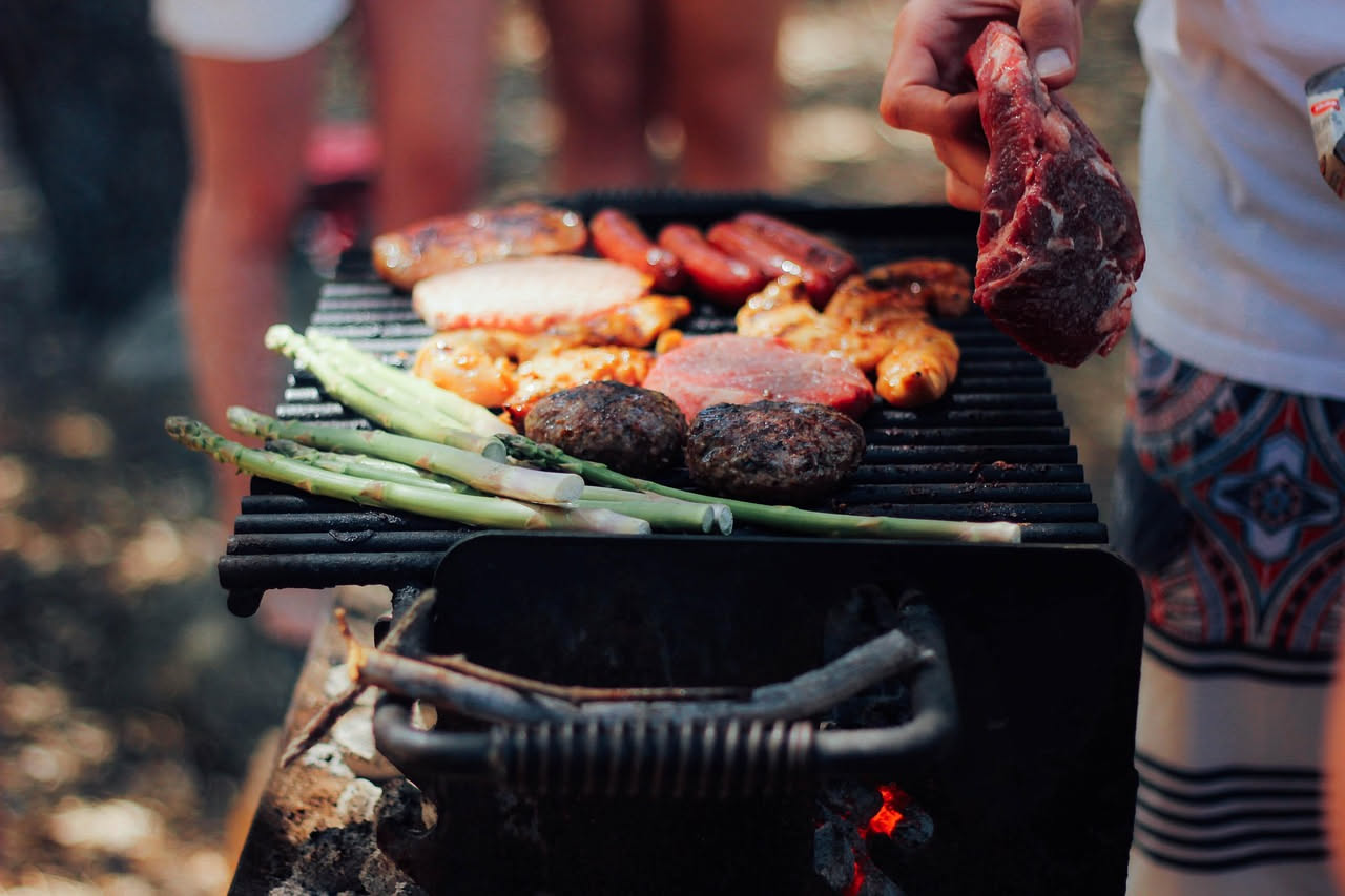 Griglia del barbecue pulita con spazzola di metallo e ciotola con miscela di aceto e bicarbonato di sodio su superficie esterna