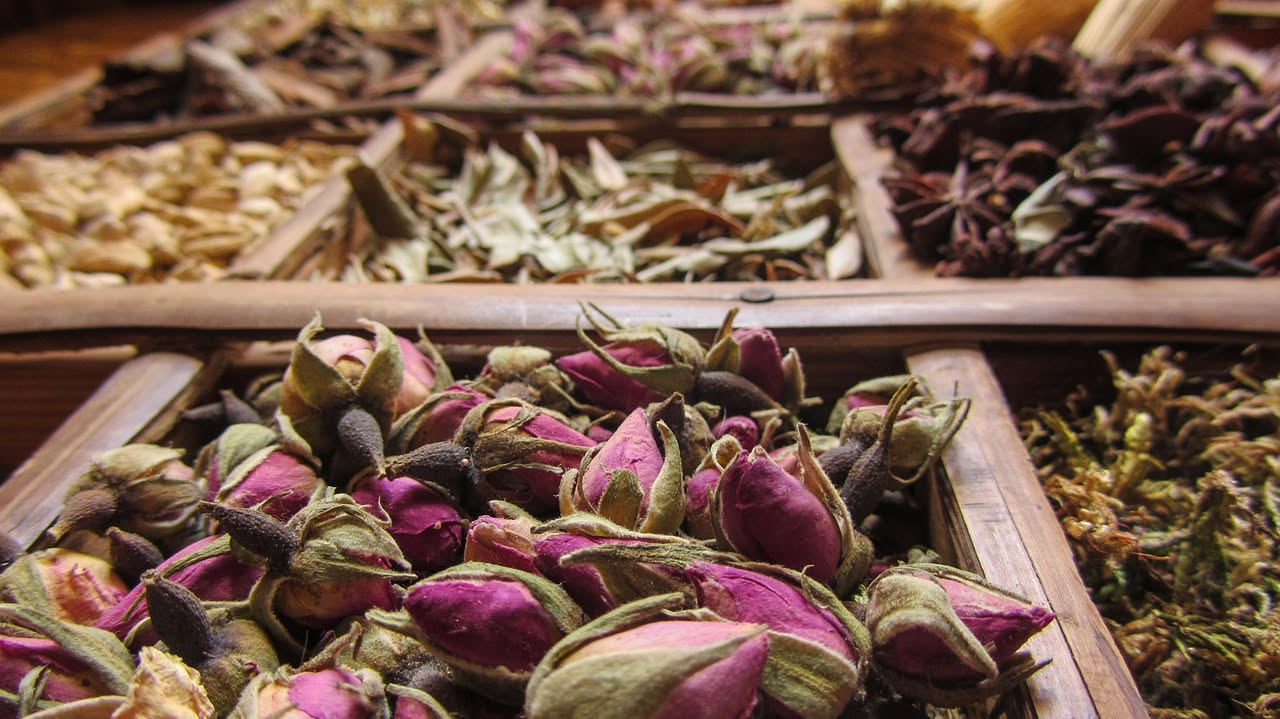 Cassetto di legno aperto con accanto una ciotola di bicarbonato, limoni freschi, rami di lavanda essiccata e un panno di cotone naturale su sfondo chiaro