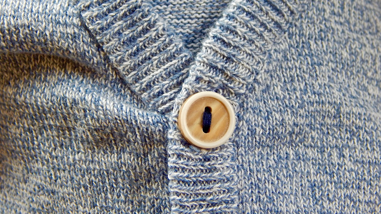 Dettaglio ravvicinato di fibre di lana merino finissima al microscopio, con superficie liscia e colore naturale bianco avorio